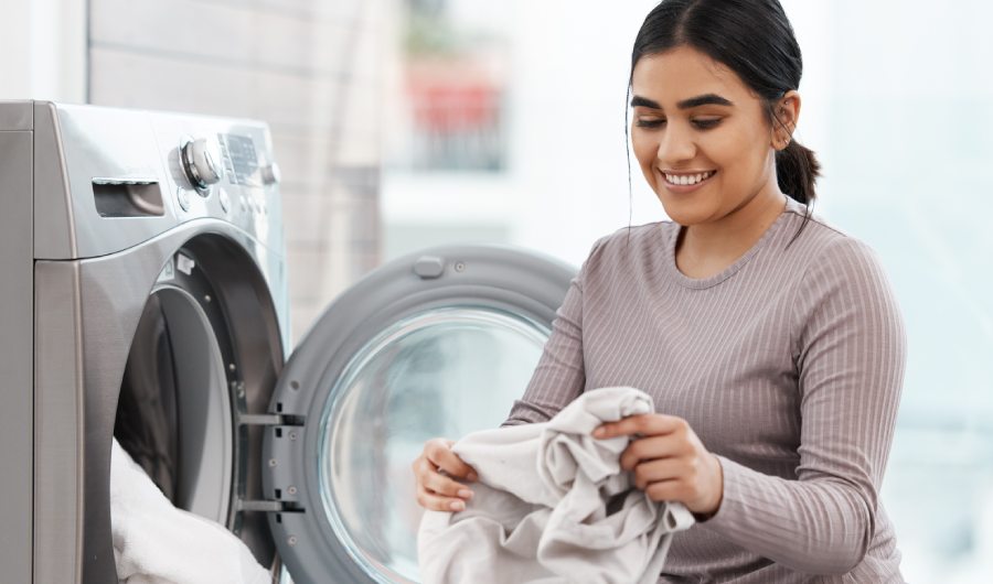 No stains are safe. Shot of a beautiful young woman doing the laundry at home.